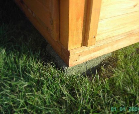 Drevený záhradný domček VOLOVEC – detail rohu základu na trávniku